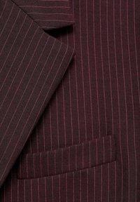 Veste de costume bordeaux foncé à fines rayures avec un col cranté et une poche poitrine passepoilée visible.