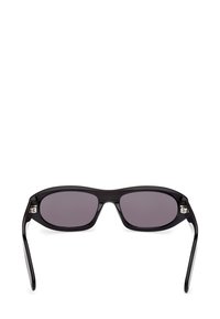 Lunettes de soleil noires rectangulaires avec des verres teintés foncés et des branches légèrement courbées, affichées de face sur un fond blanc.