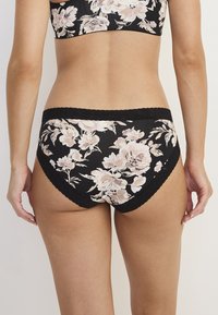 Schwarze Slip mit Blumenmuster und Spitzenbesatz, versehen mit einem pinken und cremefarbenen Blumenmuster auf glattem Stoff. Für Komfort und Passform entworfen.