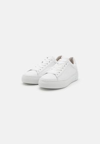 Weiße Ledersneaker mit glatter Oberfläche, runder Spitze und flacher Gummisohle. Mit Schnürsenkeln und dezenten Seitennähten.