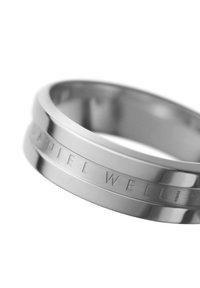 Ruostumattomasta teräksestä valmistettu rengas, jossa on sileä, kiillotettu pinta. Rengasta koristaa kaiverrettu teksti "DANIEL WELLINGTON" teksturoidulla bändillä. Pyöreä muoto.