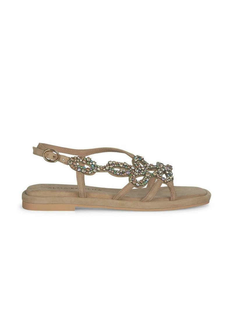 Beige flache Sandalen aus weichem Wildleder mit dekorativen Kristallakzenten und einem Riemen mit einer Metallschnalle hinten.