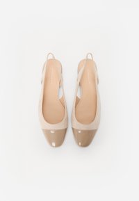 Beige nubukist slingback kingad, millel on läikiv helepruun lakk-nina ja sile nahkistme. Avatud konts ja õhukesed rihmad.
