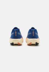 Baskets de sport bleues avec un textile texturé, une semelle rembourrée et des accents orange. Présente un marquage "1080" sur le talon.
