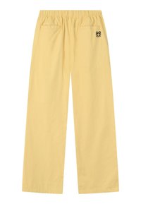 Pantalones amarillos de pierna ancha con cintura elástica, dos bolsillos traseros y un pequeño bordado de flor negra en el bolsillo trasero derecho.