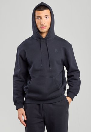 Black hoodie with a front pocket and drawstring hood, made from soft fabric. Features a small brand logo on the upper chest.