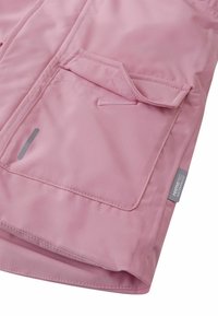Różowa wodoodporna kurtka o gładkiej fakturze, z dwoma przednimi kieszeniami, małą metką z logo oraz przeszyciami na krawędziach.
