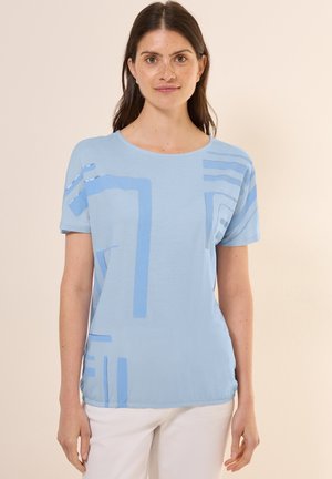Camiseta de algodón de color azul claro con mangas cortas y patrones geométricos en azul más oscuro. Presenta un escote redondo y un corte relajado.