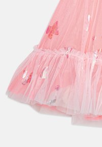 Růžové tylové šaty s volánkovým lemem, zdobené barevnými vzory motýlů a duhovými akcenty. Jemná, lehká textura.