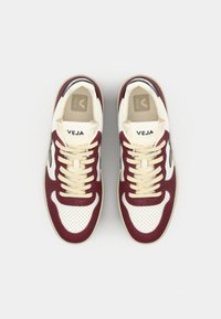Sneakers med øvre del i hvitt lær, burgunder semsket skinndetaljer, perforert tåboks, beige snøringer, og en logo på tungen. Tynn gummisåle.