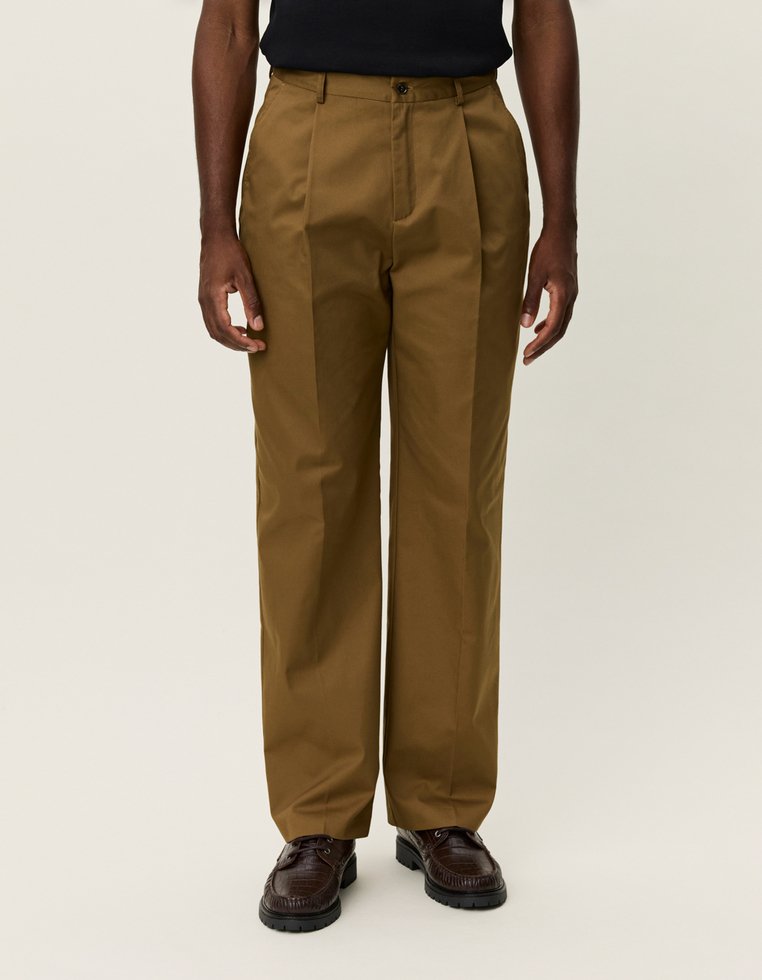 Khaki színű, egyenes szabású nadrág, tartós anyagból készült. Gombos záródással, övhurkokkal és elülső hajtással rendelkezik.