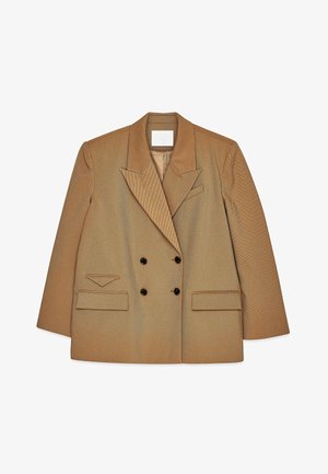 Beige topelt katteloheline bleiser, millel on laiad kraed, kaks esistooti taskut, tumedad nupud ja lõhenenud rinnatasku valge tausta peal.