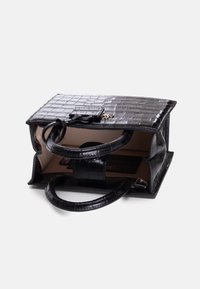 Borsa in pelle nera con stampa coccodrillo, dotata di due manici robusti, forma rettangolare, apertura superiore e foderatura interna beige con una tasca.