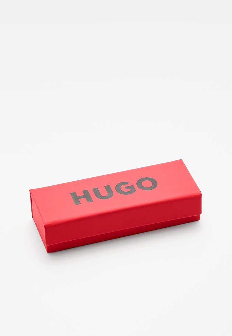 Scatola rettangolare rossa con una superficie liscia, con la parola "HUGO" in caratteri neri in grassetto sulla parte superiore. Design sottile e piatto.