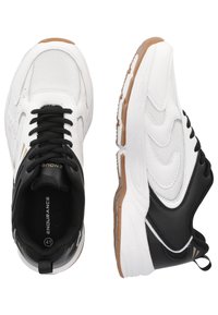 Vita och svarta sportskor med ovandel av mesh, snörning, gummisula och texturerade detaljer. Storlek 41 anges inuti.