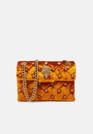 Bolso pequeño de terciopelo acolchado naranja con adornos redondos, un cierre dorado en forma de mano y una correa de cadena dorada gruesa.