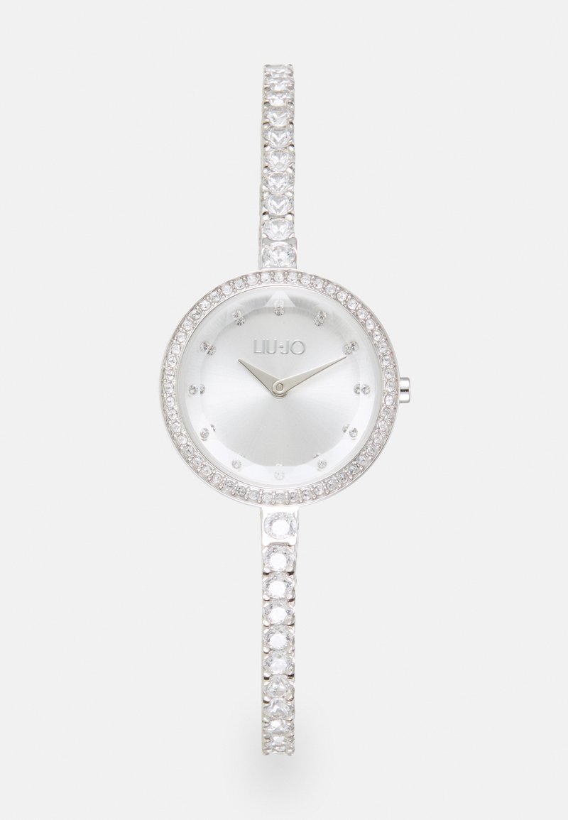 Orologio da polso argento con quadrante rotondo, dettagli in cristallo attorno alla lunetta e un bracciale tempestato di gemme. Presenta un quadrante minimalista con lancette argentate.