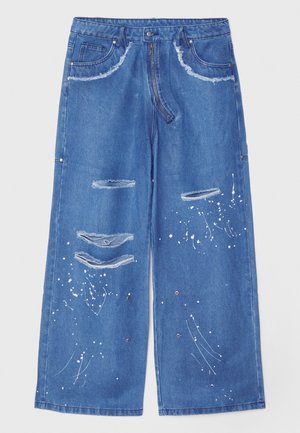 Bredde ben blå denimbukser med slitte detaljer, malingssprut aksenter, fem lommer og knappestengsel.