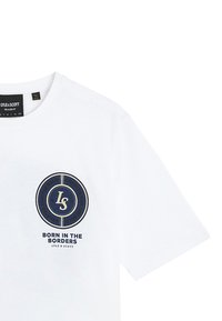 Hvid kortærmet T-shirt med rund hals, med et navy og beige cirkulært logo og teksten "Born in the Borders Lyle & Scott" på brystet.
