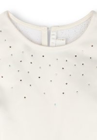 Robe en tissu ivoire avec un col rond et une fermeture éclair dans le dos, ornée de petits strass colorés sur le devant.