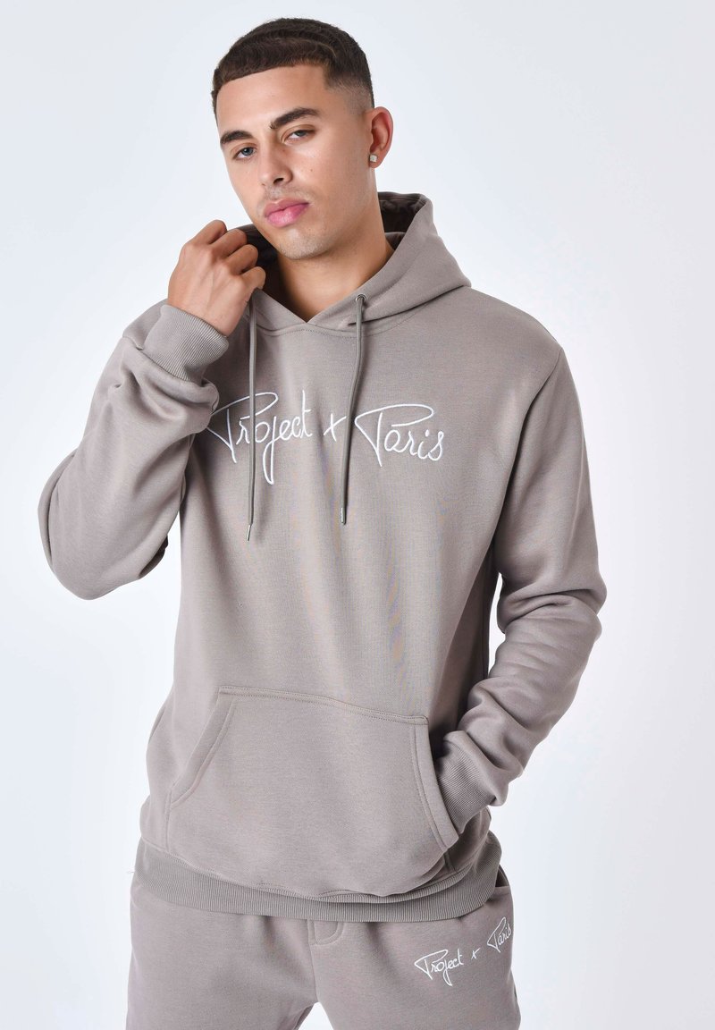 Sudadera con capucha gris, con cordones y bolsillo frontal, que presenta el texto bordado en blanco "Project + Paris". Tejido suave y puños acanalados.