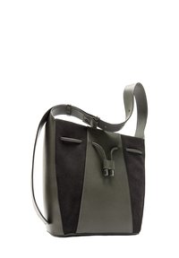 Ciemnozielona skórzana torebka z zamszu o wyraźnym kształcie, z regulowanym paskiem i podwójnymi kieszeniami. Posiada unikalny detal zapięcia.