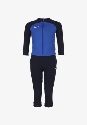 Blauer und marineblauer Sport-Trainingsanzug aus dehnbarem Stoff; enganliegende Jacke mit Reißverschluss und Dreiviertelärmeln, passende enganliegende Hose mit Logoakzenten.