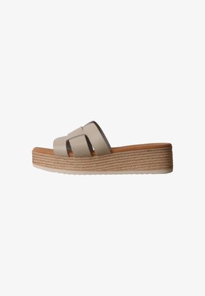 Sandale plateforme beige avec larges brides en cuir et détails en corde tressée sur la semelle épaisse, présentée sur fond blanc.