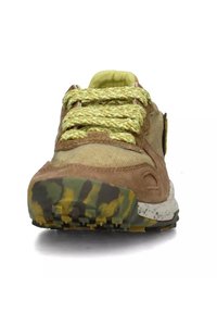 Brown suede and mesh sneaker with yellow and green camo sole, textured laces, and padded tongue. Features a circular logo on the side.