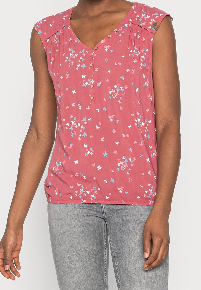 Haut sans manches rose avec imprimé papillon en bleu et blanc. Dispose d'un col en V, d'une patte de boutonnage et de détails plissés aux épaules.