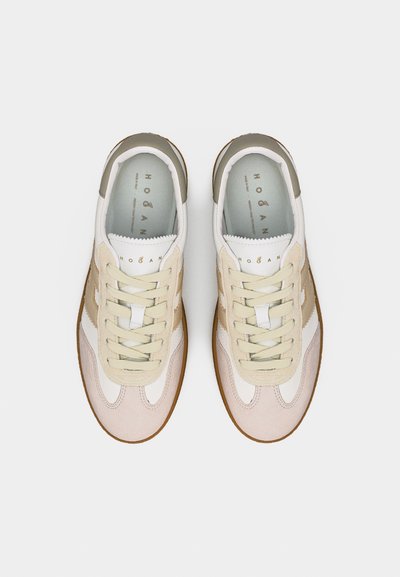 Paire de baskets en cuir beige et blanc de la marque Hogan, avec des lacets crème et des semelles en caoutchouc marron, vue de dessus sur un fond blanc.