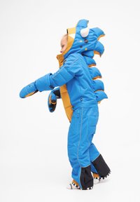 Blå og orange børne dunjakke med hætte, der har pigge og kløer, designet til varme. Inkluderer vandtætte manchetter og blød foring.