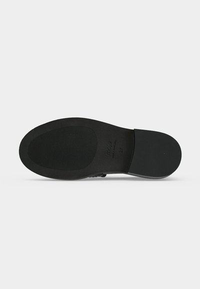 Semelle de chaussure noire avec zone de grip texturée, talon lisse, et numéro de taille 37 visible sur un fond clair uni.