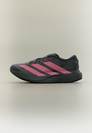 Chaussure de running noire avec trois grandes bandes roses sur le côté et semelle épaisse, sur fond gris clair neutre.
