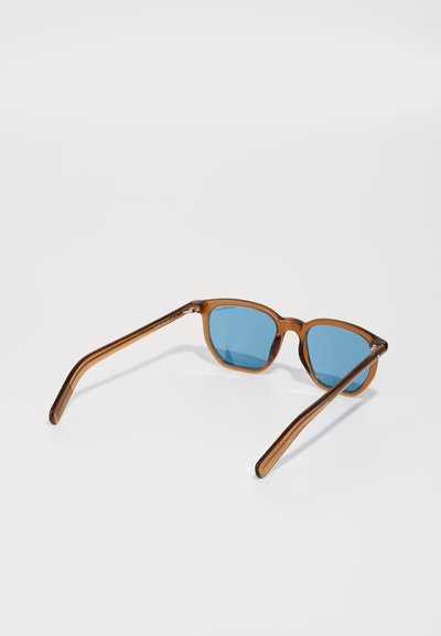 Ochelari de soare din plastic brown cu lentile albastre, având o formă pătrată, brațe texturate de culoare brown și accente metalice la balamale.