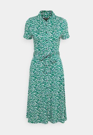 Robe courte à manches courtes verte avec boutons, imprimé floral blanc et violet, et ceinture à la taille.