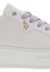 Bílé tenisky s levandulovými tkaničkami, zlatým metalickým logem jezdeckého koně a čistým podrobným prošíváním na bočním panelu.