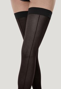 Bas noirs jusqu'aux cuisses avec un motif à losanges et une bande élastique lisse en haut. Le tissu a une texture douce et transparente.