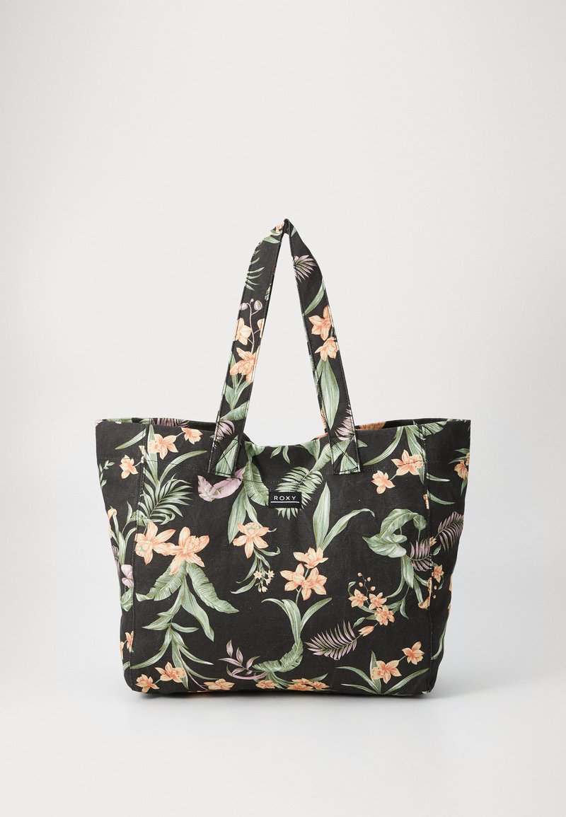 Black fabric tote bag with a floral pattern in orange and green. Features two sturdy handles and a label on the front.