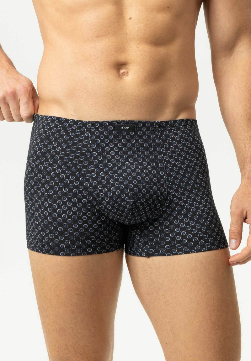 Male torso wearing black boxer briefs with a blue geometric square pattern, pulling waistband slightly outward on one side.