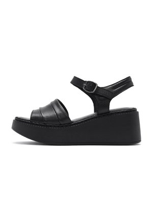 Sandalo nero con zeppa, cinturino alla caviglia, chiusura con fibbia e ampio cinturino anteriore imbottito, mostrato di lato su sfondo bianco.