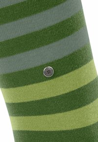 Calze verdi a righe realizzate in tessuto morbido, con strisce alternate di verde scuro, verde chiaro e grigio, arricchite da un dettaglio circolare con logo argentato.