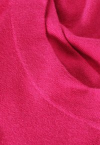 Fuchsia gestrickter Stoff mit einer weichen Textur und einem drapierten Aussehen, der ein dezentes meliertes Muster und glatte, abgerundete Kanten aufweist.