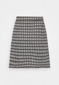 Jupe texturée noire et blanche longueur genou avec un motif tissé à carreaux et une silhouette droite.
