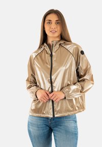 Giacca zip-up oro metallizzato con cappuccio, dettagli neri e polsini elasticizzati. Tessuto liscio e lucido con una vestibilità comoda.