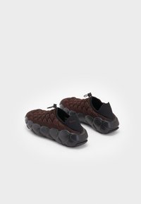 Nike-sko med en strukturert, bordeaux mesh-overdel og en tykk svart gummisåle. Har en slip-on design med en stropp bak.