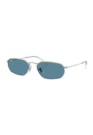 Solbriller med sølvramme, blåtonede, uregelmæssige sekskantede linser og tynde stænger, med Ray-Ban-logo på øverste venstre linse.
