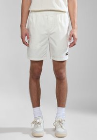 Witte, lichte shorts met een elastische tailleband, zijzakken en een klein logo-label. Soepele textuur, lengte boven de knie.