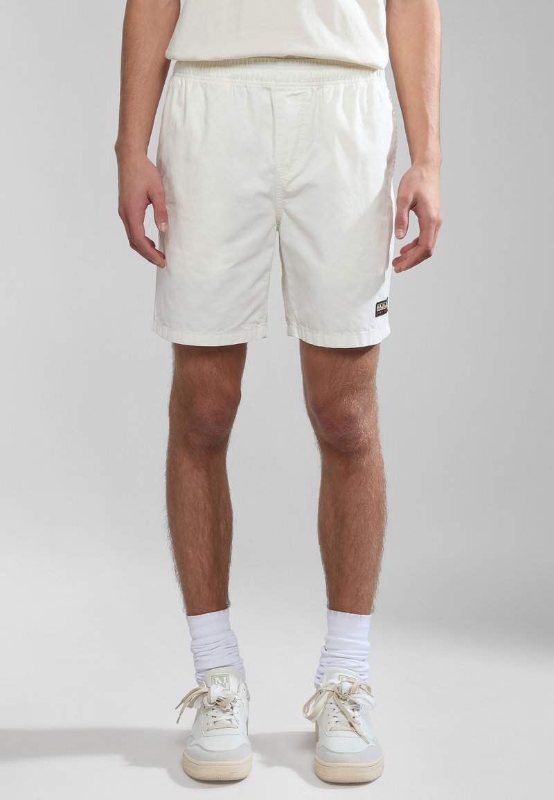 Witte, lichte shorts met een elastische tailleband, zijzakken en een klein logo-label. Soepele textuur, lengte boven de knie.