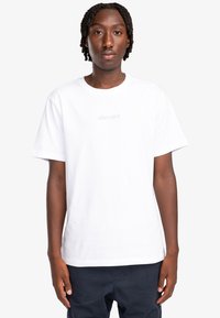 Camiseta blanca de algodón con mangas cortas, corte relajado, que presenta un sutil logotipo beige "element" en el pecho. Textura suave, diseño clásico.